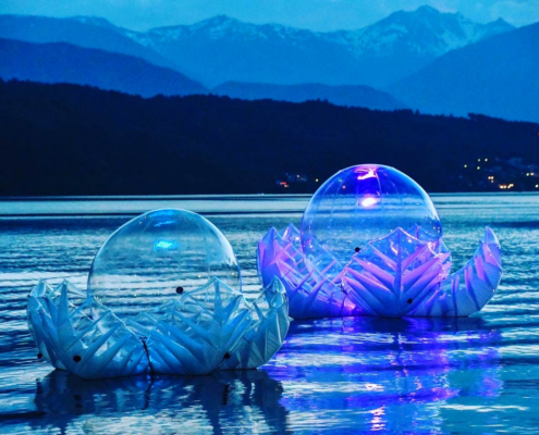 Illuminated inflatable LOTUS sculpture floating on Lake Millstatt at dawn