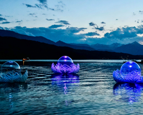 Illuminated inflatable LOTUS sculpture floating on Lake Millstatt at dawn