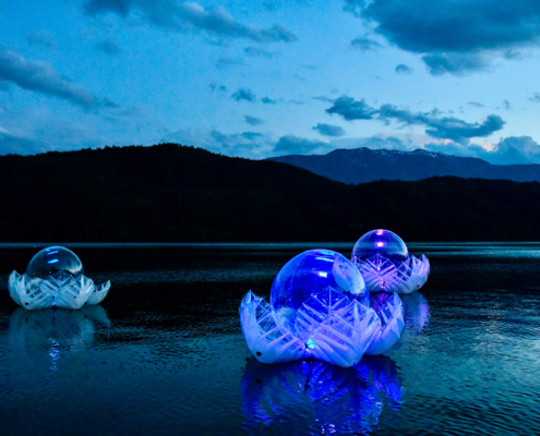 Illuminated inflatable LOTUS sculpture floating on Lake Millstatt at dawn